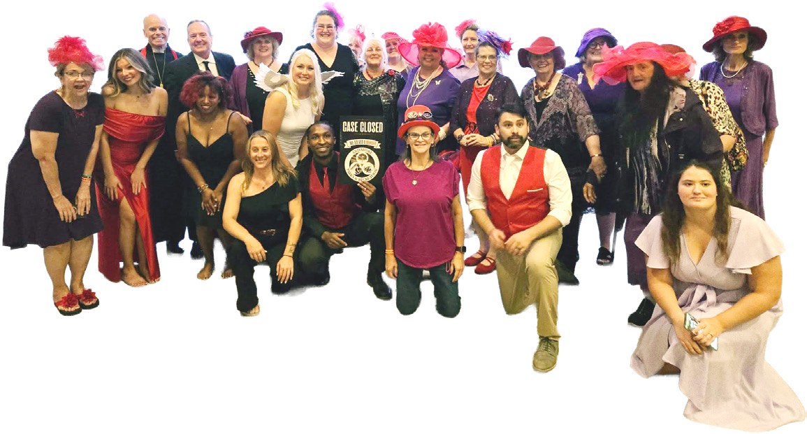 Red Hatters in red and purple hats pose with the costumed cast of the “Till Death Do Us Part” murder mystery wedding.